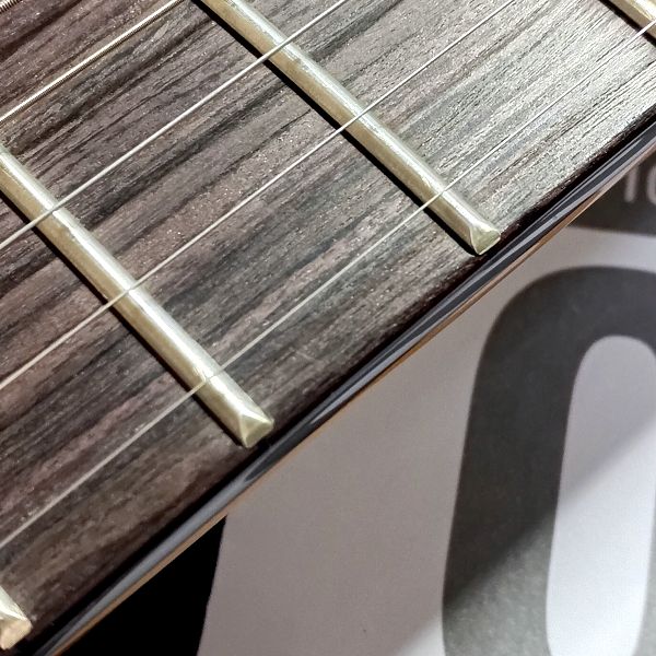 1弦のみAria Pro II (アリアプロツー) AGS-8001XL(.009P) をセットしたギターの指板 右下の背景に弦のパッケージ